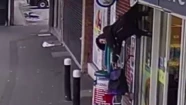 Insólito video: una señora se enganchó con la persiana de un local y quedó colgada en el aire