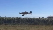 Un avión fumigando en un campo cercano al barrio Los Acantilados.