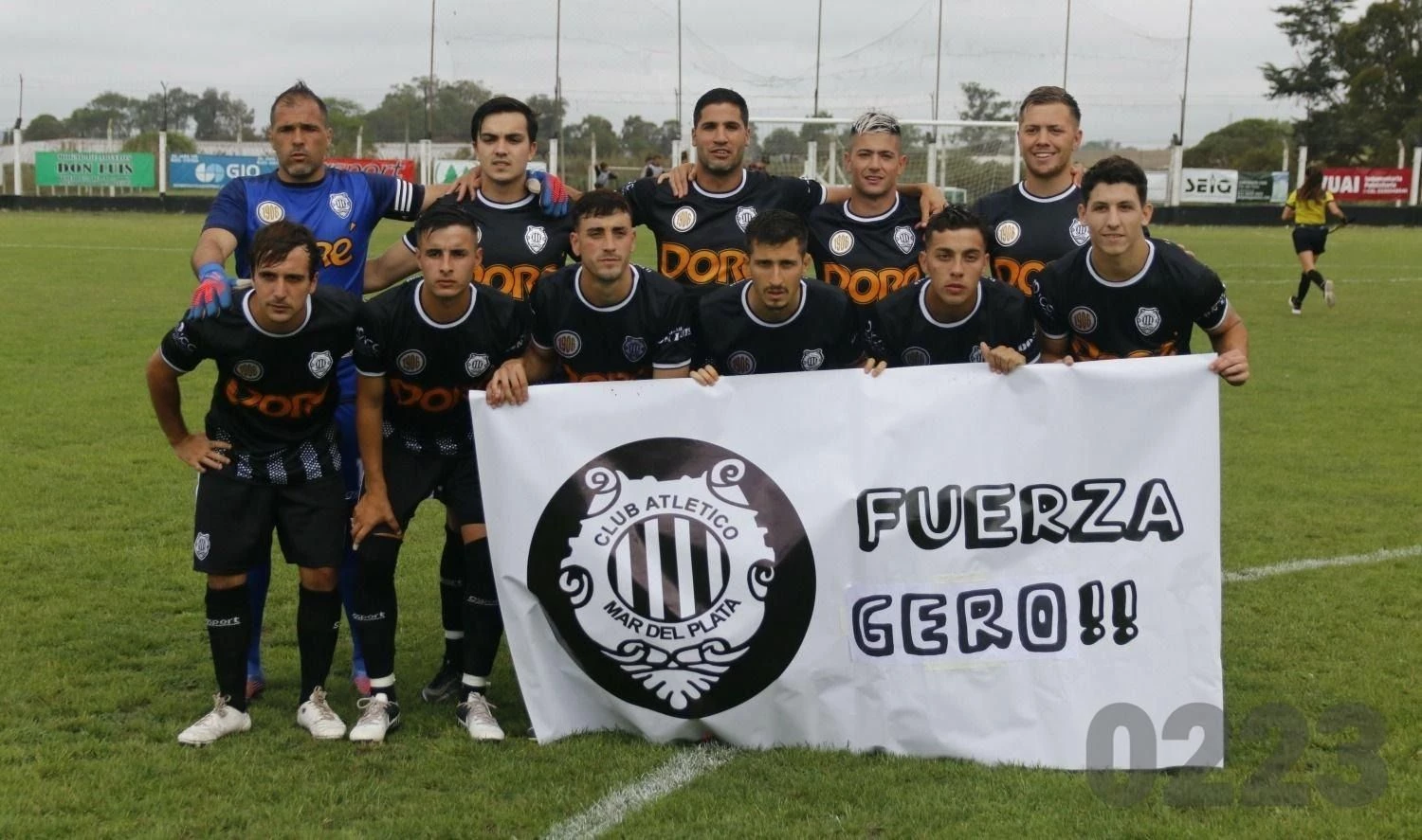 La formación de Atlético Mar del Plata y una bandera de apoyo al volante Gerónimo Echevarría, que se lesionó gravemente en la semana. 